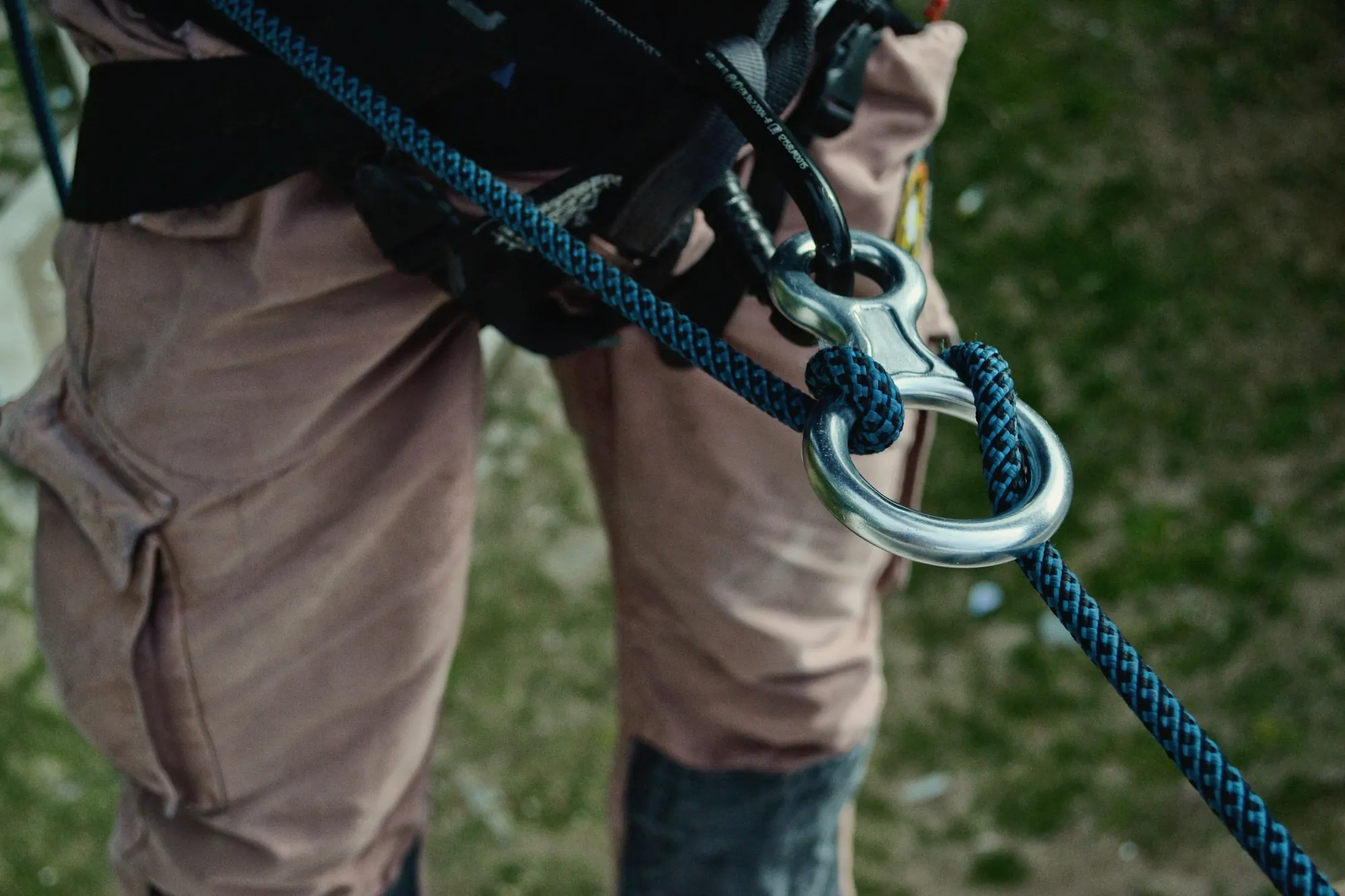 Close-up of a worker's safety harness and rope carabiner