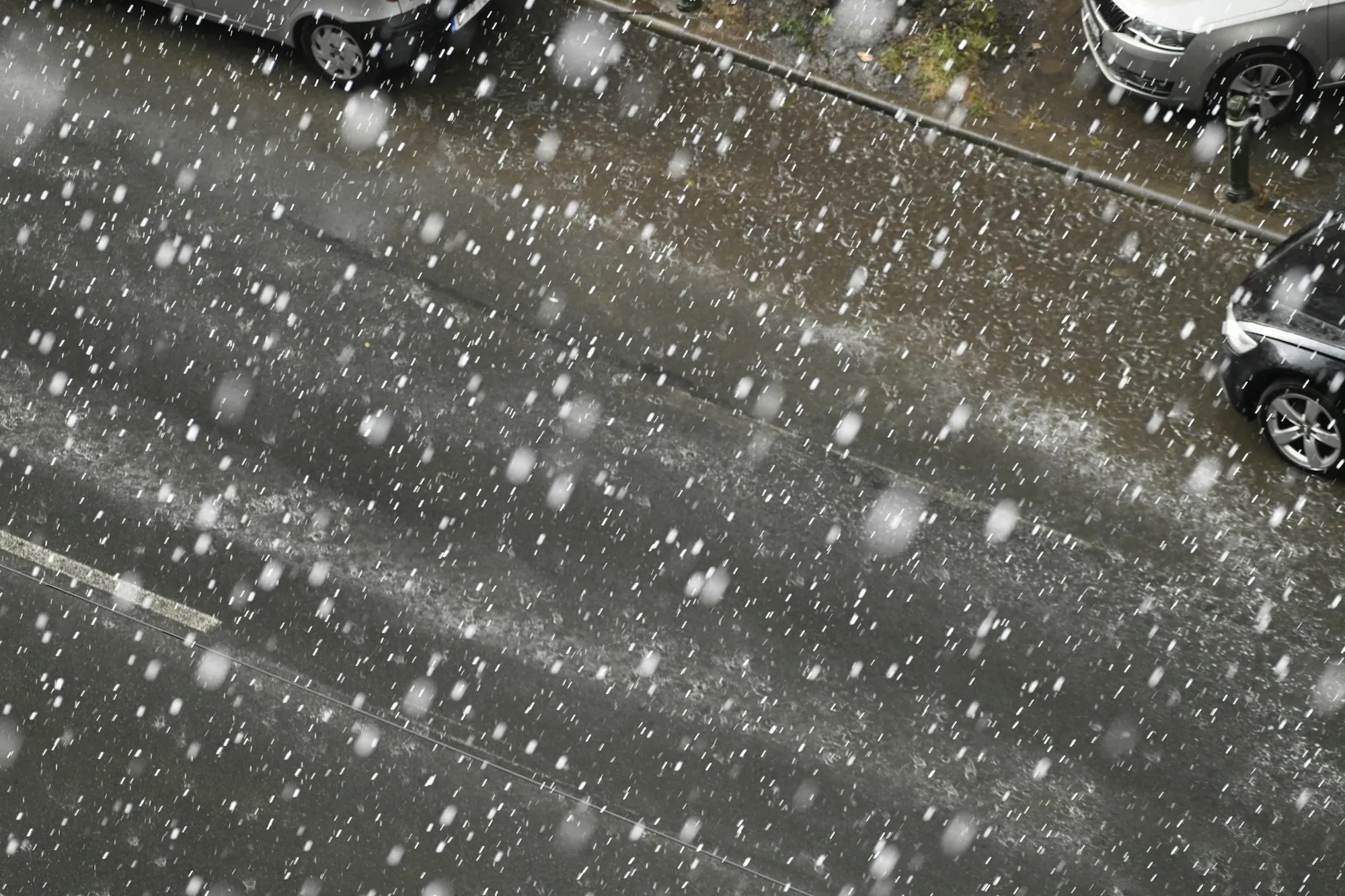 Hailstones bouncing on wet pavement during a storm